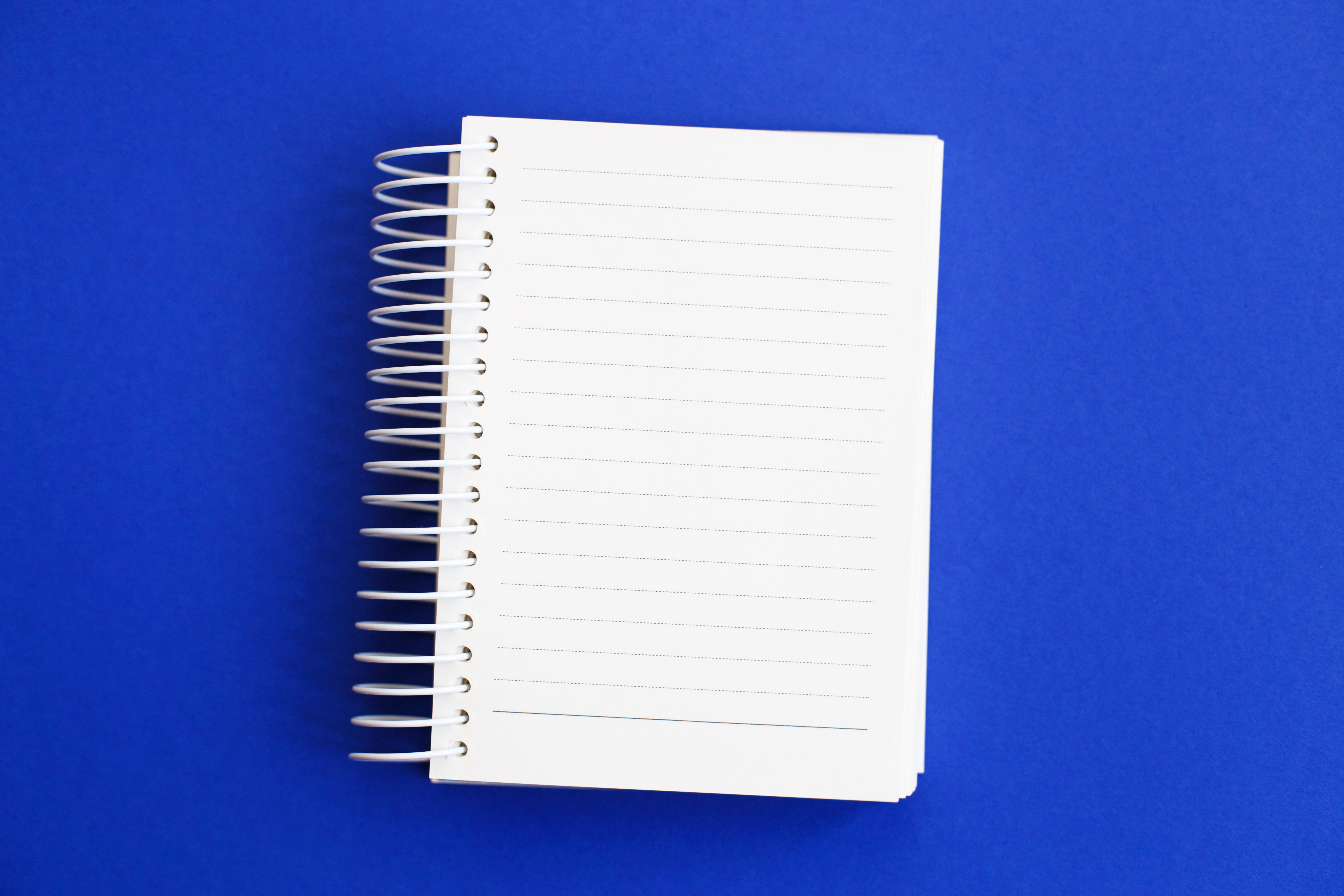 top-view-of-blank-note-paper-on-blue-background-2023-11-27-05-33-18-utc